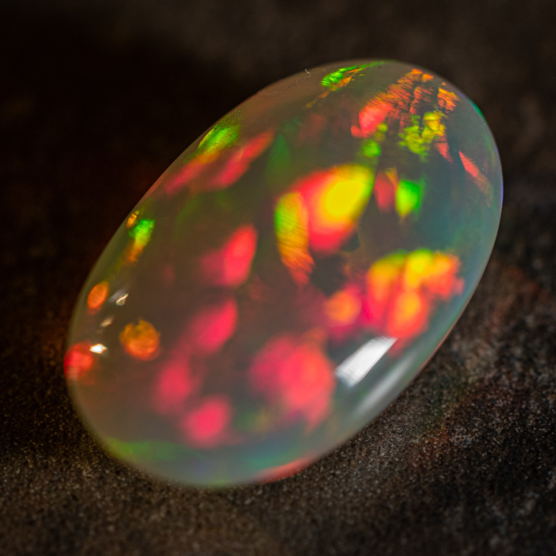 cut light opal from Coober Pedy with red and green flashes